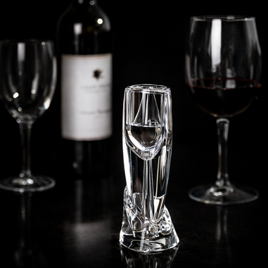 Clear wine aerator with wine glasses and a bottle in the background