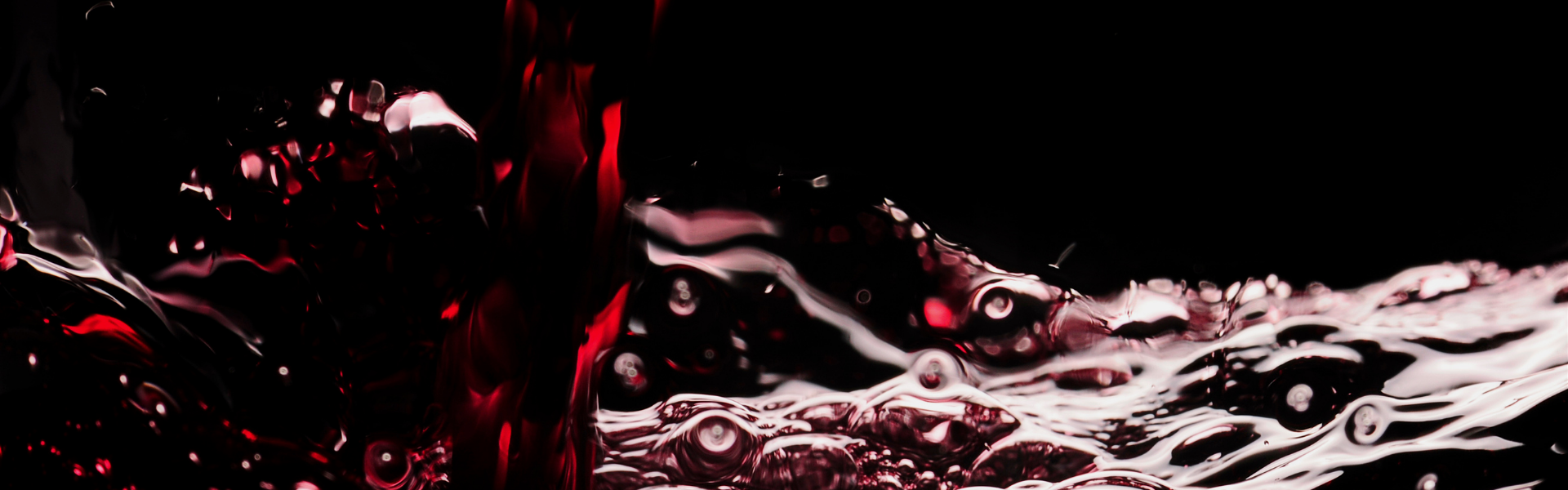 Close-up of red wine with visible bubbles against a dark background